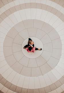 a small child is sitting on the floor by Marcos Paulo Prado courtesy of Unsplash.