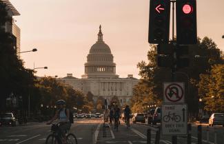 people biking on road and different vehicles viewing United States Capitol during daytime screenshot by Andy Feliciotti courtesy of Unsplash.