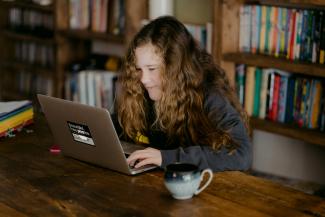 woman in black jacket using macbook pro by Annie Spratt courtesy of Unsplash.