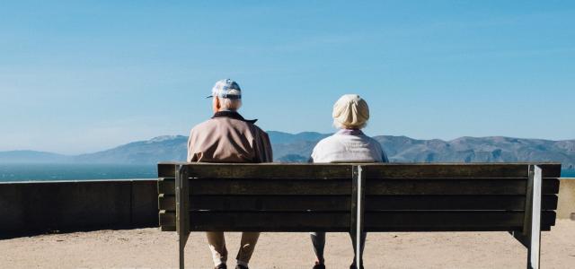 man and woman sitting on bench facing sea by Matt Bennett courtesy of Unsplash.